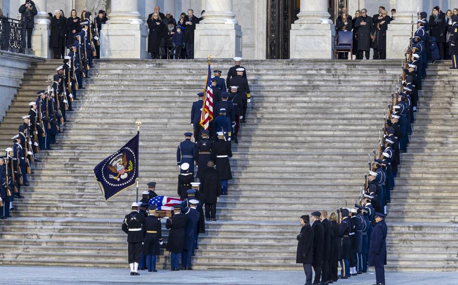 Service members line both sides of the steps as other members of the armed forces carry Jimmy Carter’s casket into the Capitol.