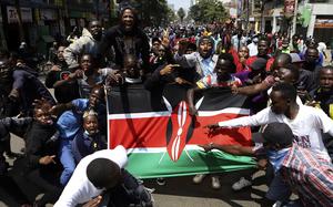 Demonstrators carry a Kenyan flag during a protest in Nairobi, Kenya, Tuesday, July 23, 2024. Anti-government protesters in Kenya’s capital clashed with a pro-government group on Tuesday, leading to the burning of a motorcycle that belonged to people who were voicing their support for the president. 