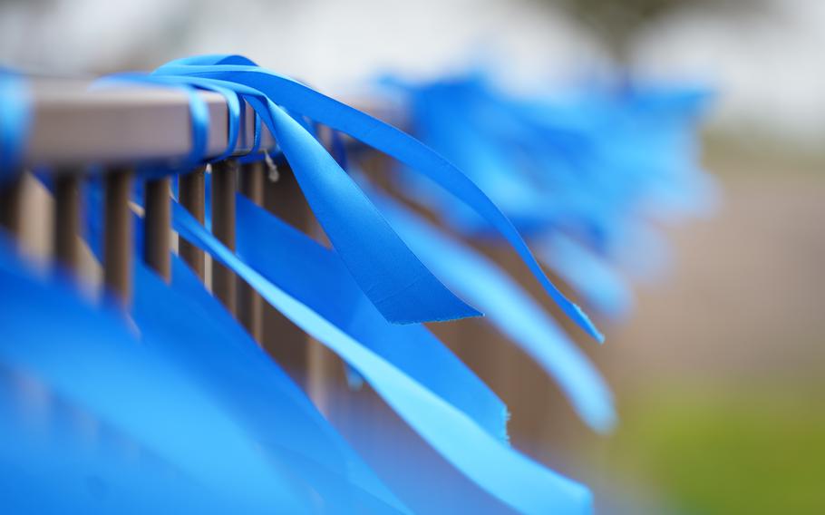 Blue ribbons tied to a railing.