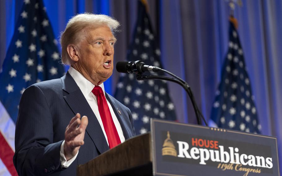 President-elect Donald Trump speaks into a microphone on a podium with American flags in the background.