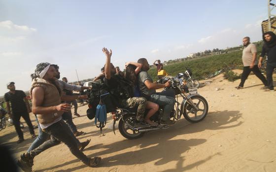 FILE - Palestinians transport a captured Israeli civilian, Noa Argamani, on a motorcycle from southern Israel, in the Gaza Strip on Oct. 7, 2023. Victims of Hamas' Oct. 7 attack in Israel sued Iran, Syria and North Korea on Monday, July 1, 2024, saying their governments supplied the militants with money, weapons and know-how needed to carry out the assault that precipitated Israel's ongoing war in Gaza. 