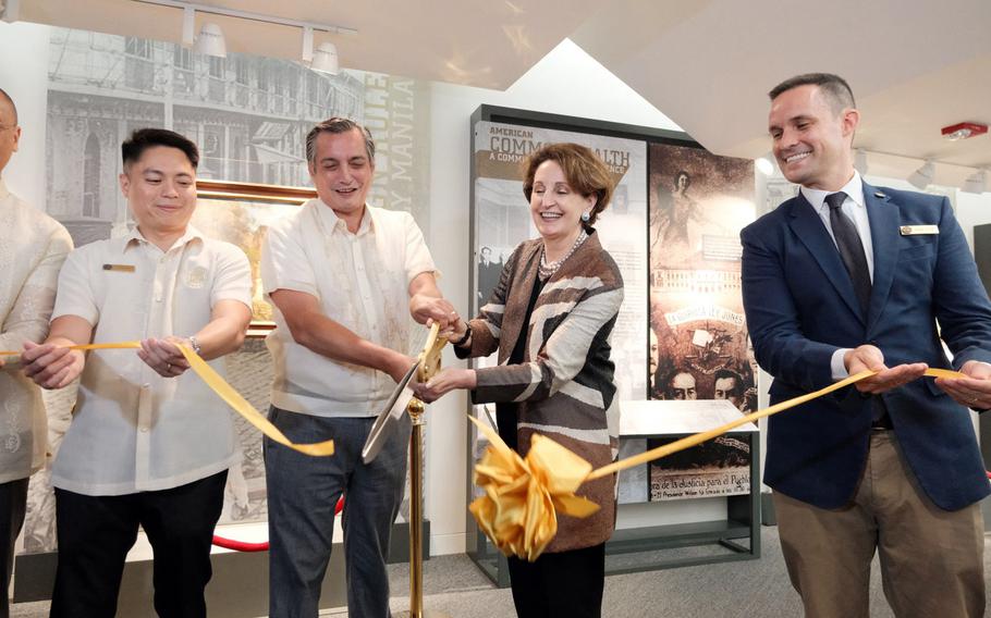 The U.S. ambassador to the Philippines cuts a yellow ribbon.