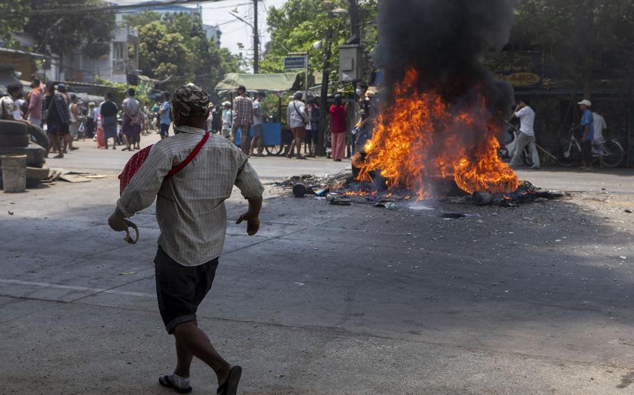 A protester skirts a pile of burning tires during a demonstration against the junta in Yangon, Myanmar, on March 31, 2021. 