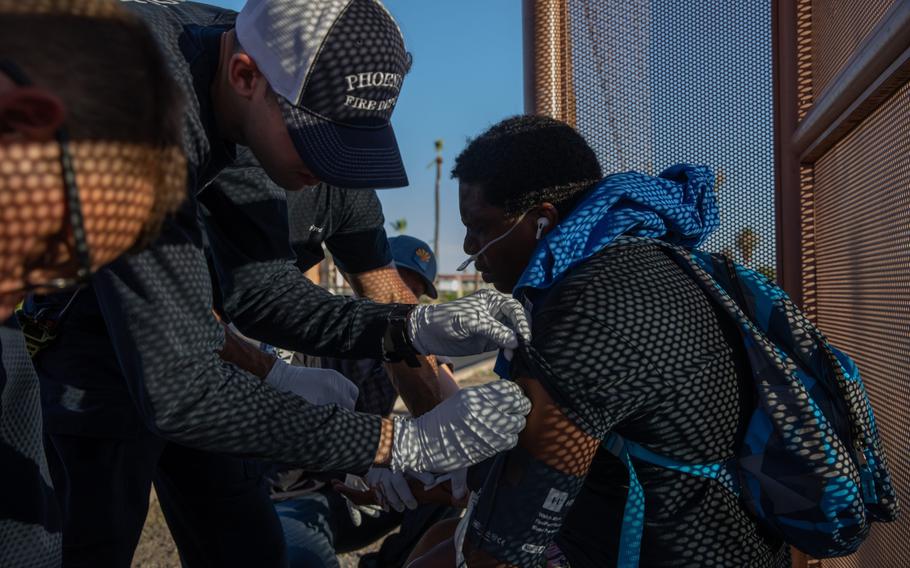 Firefighters check the vital signs of a resident having trouble breathing during a heat wave in Phoenix, July 20, 2023.