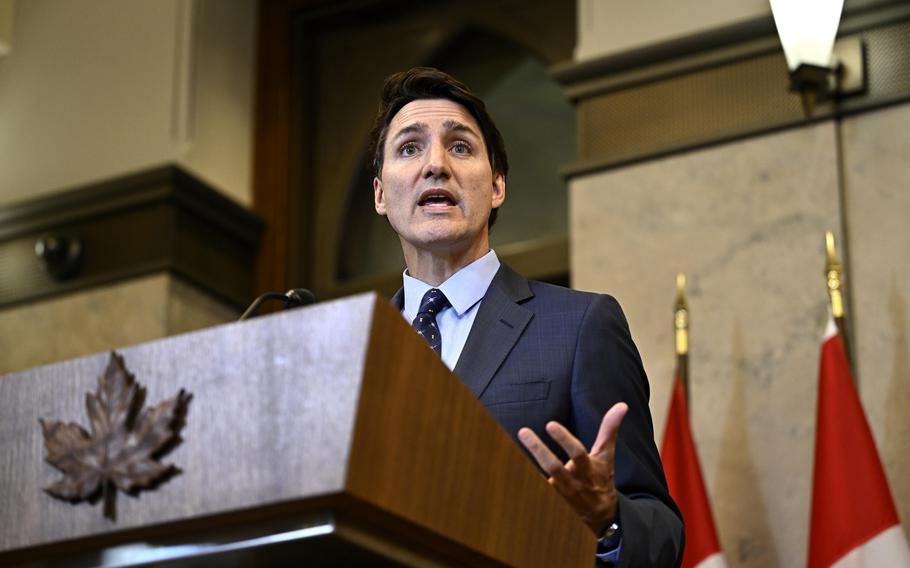 Justin Trudeau speaks from a lectern adorned with a maple leaf.