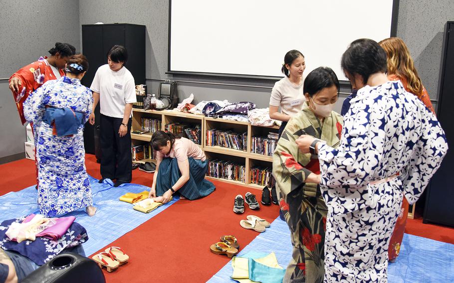 Japanese service members help their American counterparts wear yukata, an unlined summer kimono, during a cultural exchange at the USO on Yokota Air Base, Japan, July 22, 2023. 