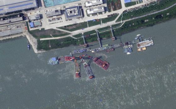 A satellite image of what appears to be a sunken Chinese submarine in the water, alongside a pier.