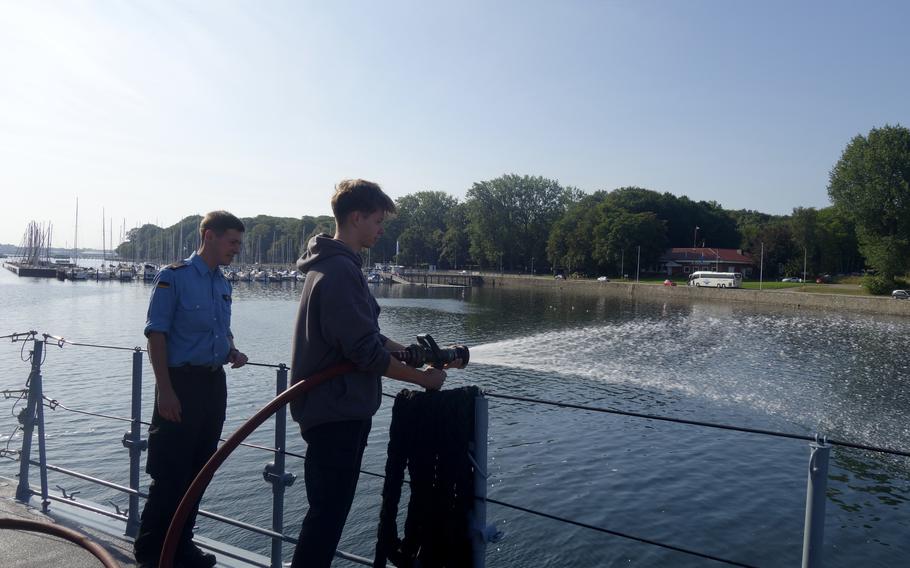 A German service member demonstrates firefighting methods from a ship