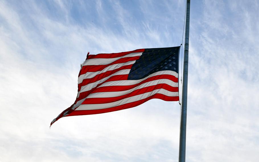 An American flag flies at half-staff.