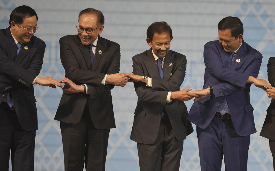 The leaders of Laos, Malaysia, Brunei and Cambodia hold hands for a photo during the opening of the ASEAN summit in Laos, Oct. 9, 2024. 