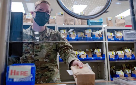 A pharmacy technician with the 18th Medical Support Squadron hands a prescription to a patient at Kadena Air Base, Okinawa, Nov. 16, 2021. 