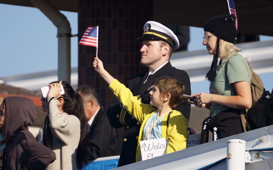 Family members and friends wait pierside as the aircraft carrier USS George Washington arrives at Yokosuka Naval Base, Japan. Nov. 22, 2024.