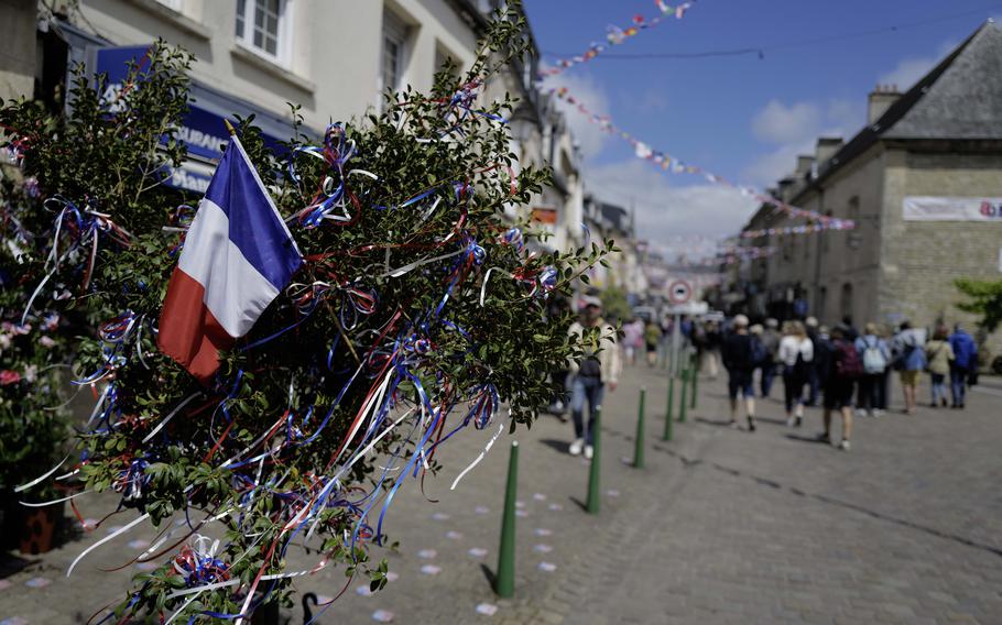 A small French flag waves during D-Day commemoration events in Normandy. Four U.S. soldiers were injured in a bus crash near Sainte-Mère-Église Saturday while traveling to a football game as part of the 80th anniversary festivities.
