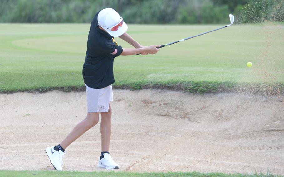 Kadena sophomore Kai Redden blasts out of a bunker during Thursday’s DODEA-Okinawa two-player scramble play at Taiyo Golf Course in Gushikawa. Redden and sophomore teammate Benjamin Decker beat Kubasaki’s Mason Ramos and Ryan Gavin 43-47; 