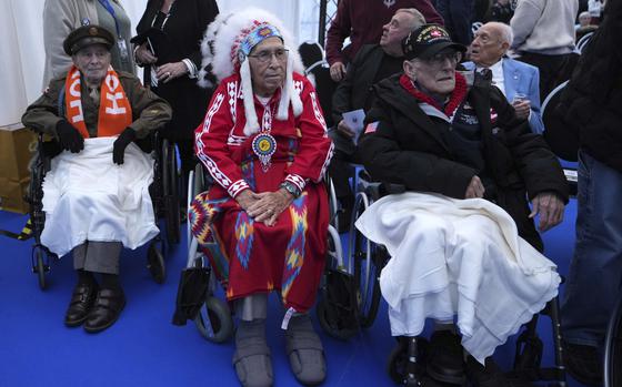 World War II veterans sit in wheel chairs at a commemoration event.