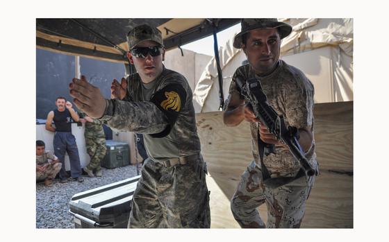 Mosul, Iraq, Aug. 20, 2010: Sgt. Ryan Carlson, left, shows an Iraqi soldier how to raid a home at Checkpoint 3, a small base outside Mosul. Training the Iraqi security forces will be key as the U.S. nears the 2011 deadline to withdraw all troops.

See additional photos and read the 2010 article here.
https://www.stripes.com/history/2010-08-25/soldiers-remaining-in-iraq-expect-little-will-change-as-mission-evolves-1903267.html1

META DATA: Iraq; Wars on Terror; 3rd Squadron, 7th Cavalry Regiment; withdrawal; Operation New Dawn; 1st Battalion, 64th Armor Regiment; 3rd Infantry Division