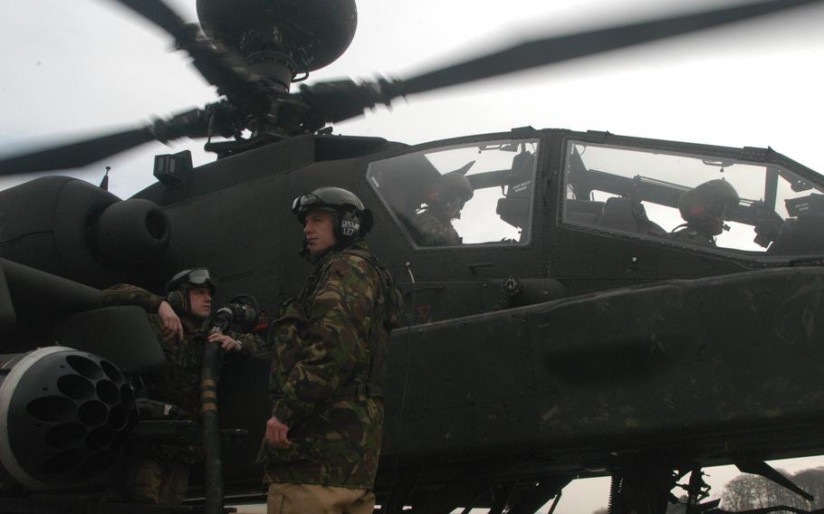 British maintainers gas up a British Apache helicopter