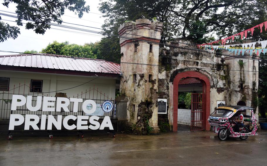 A sign outside of a gated compound says Puerto Princesa.