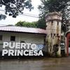 A sign outside of a gated compound says Puerto Princesa.