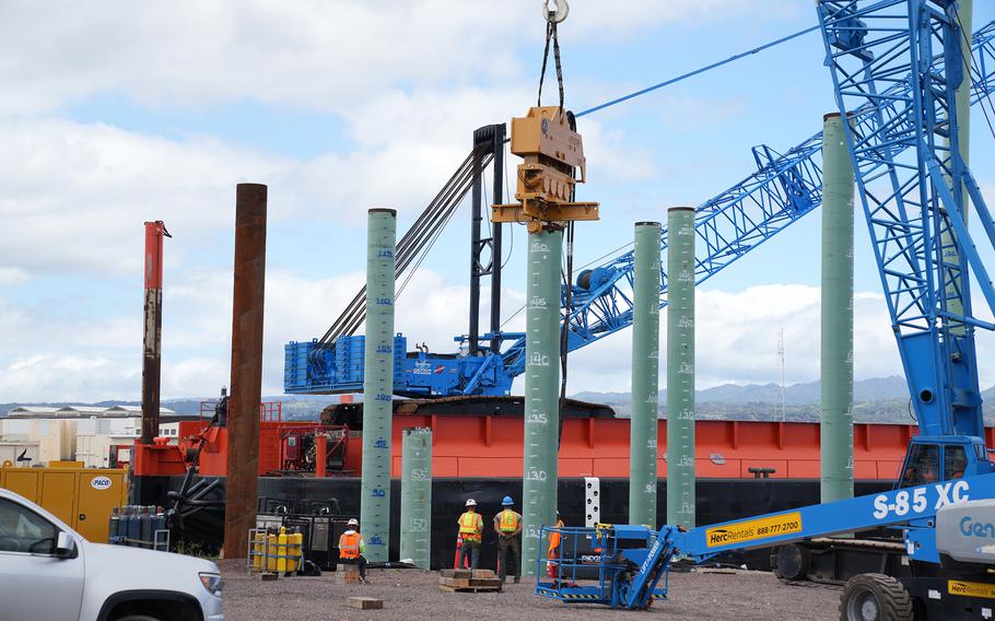 Three-foot diameter piles are driven in by a vibratory hammer, March 18, 2024, during construction of a dry dock at Pearl Harbor Naval Shipyard and Intermediate Maintenance Facility. 