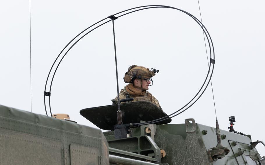 Staff Sgt. Shaun Lewis looks out of the cab of a High Mobility Artillery Rocket System.