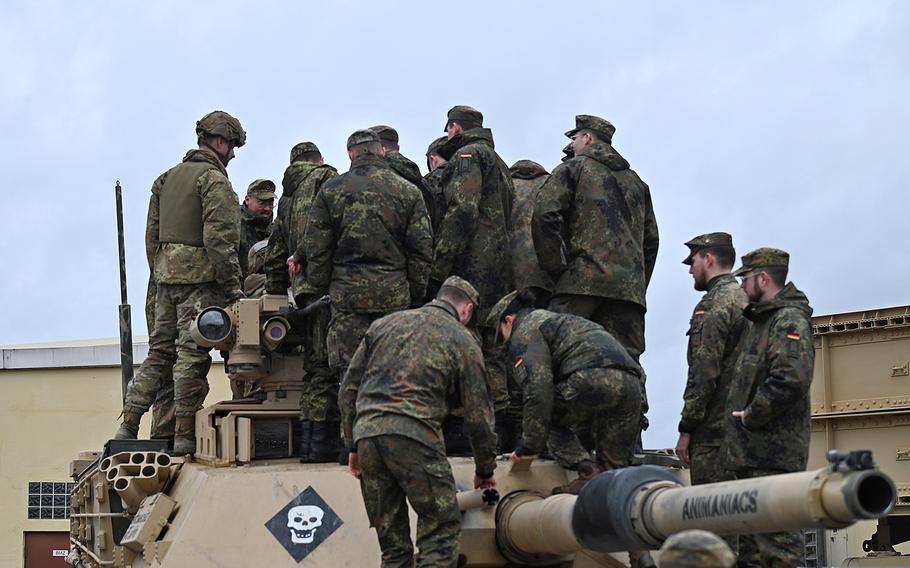 Soldiers from the German Army NCO School climb aboard an M1A2 Abrams tank 