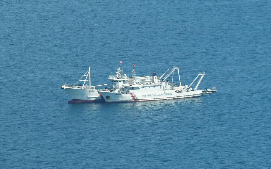 Chinese coast guard ships anchored inside the lagoon of the Chinese-controlled Scarborough Shoal, on Sept. 28, 2023, during a maritime surveillance flight by the Philippine Bureau of Fisheries and Aquatic Resources (BFAR) over disputed waters of the South China Sea. The Philippine Coast Guard vowed September 29 to "do whatever it takes" to remove any more floating barriers installed by China at a disputed reef in the South China Sea.