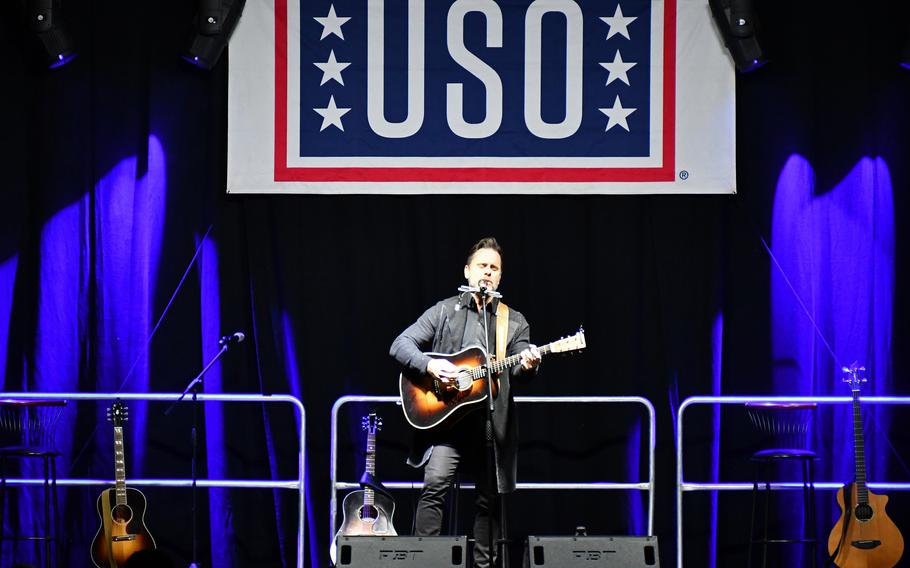 An entertainer plays for a military audience in Italy.