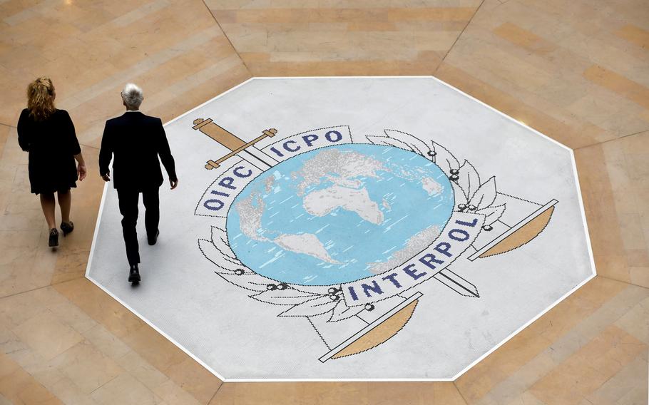 People walk on the Interpol logo 