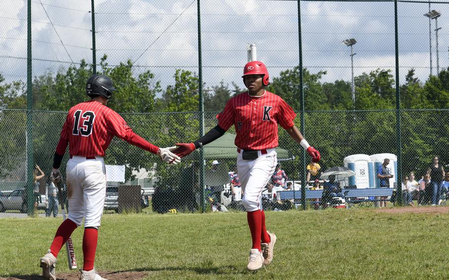 Kaiserslautern’s Rueben Todman slaps teammate James Leonard’s hand after crossing the plate late in a 2024 DODEA European baseball championship game against Wiesbaden on May 23, 2024, at Southside Fitness Center on Ramstein Air Base, Germany.