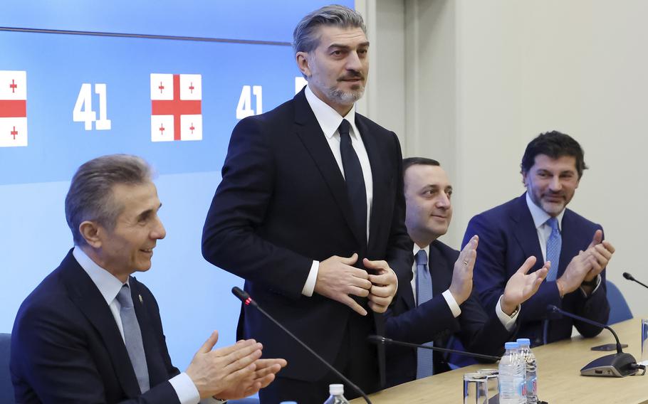 Bidzina Ivanishvili, leader of the Georgian Dream party, which he initiated, applauds Mikheil Kavelashvili during a session