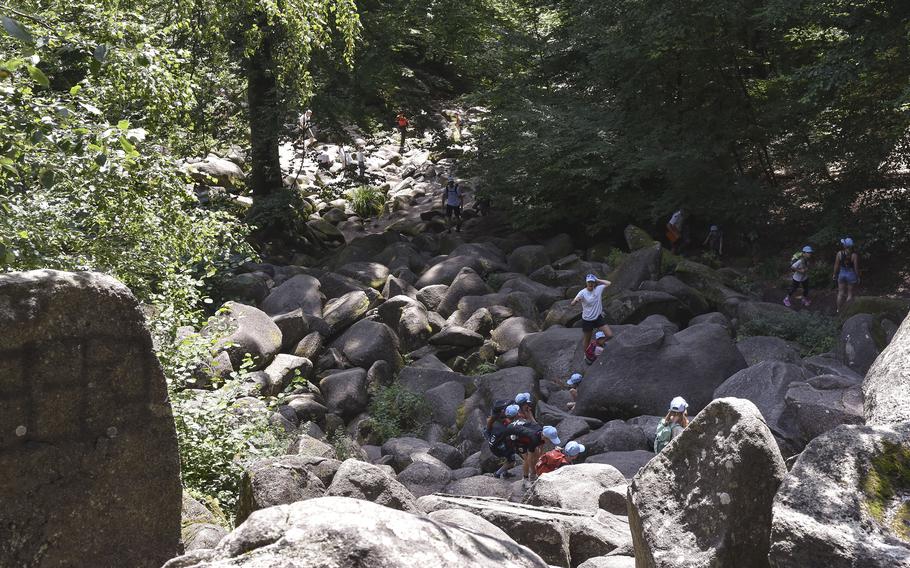 Kinder klettern auf die Felsbrocken, die das Felsenmeer im Odenwald bei Latterdal, Deutschland, bilden. Bedeutung des Namens Felsenmeer "Ein Meer aus Steinen" Auf Deutsch.