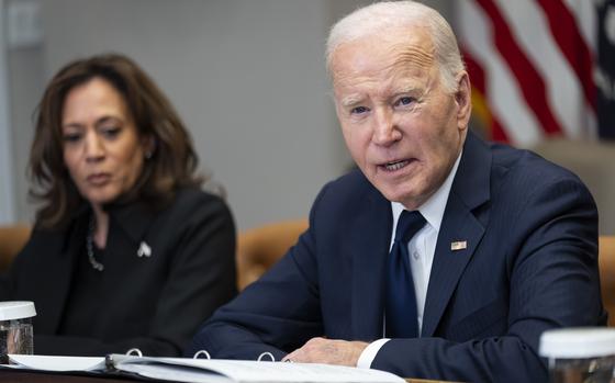 President Biden in-focus seated at a table while Vice President Harris is seated slightly out-of-focus next to him.