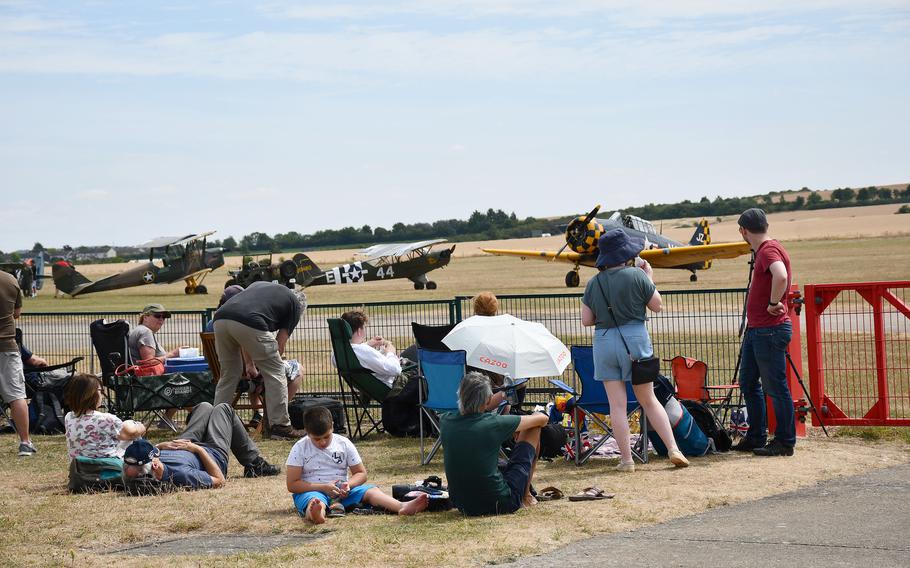 Visitors set up chairs and find space along the runway in preparation for the WWII-era American and British planes scheduled to fly in the Duxford Air Show. 