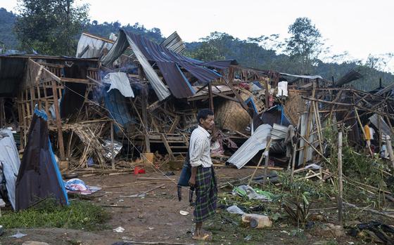 FILE - A man looks on at homes destroyed after air and artillery strikes in Mung Lai Hkyet displacement camp, in Laiza, Myanmar, Tuesday Oct. 10, 2023. (AP Photo, File)