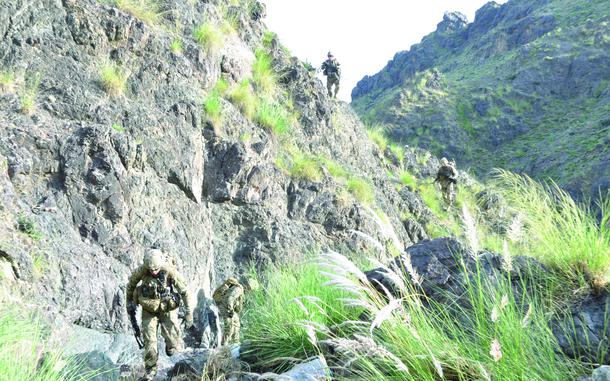 Members of Easy Company and a security advising team climb up a canyon on a patrol to support Afghan security forces during a mission in Khost province, Afghanistan.