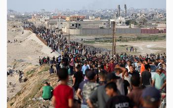 Palestinians gather in the hope of obtaining aid delivered into Gaza through a U.S.-built pier, amid the ongoing conflict between Israel and the Palestinian Islamist group Hamas, as seen from central Gaza Strip, May 19, 2024.