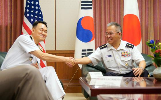 South Korean Joint Chiefs of Staff chairman Adm. Kim Myung-soo, left, shakes hands with Japanese Joint Staff chief of staff Gen. Yoshihide Yoshida during their meeting with top U.S. military leaders at Camp Ichigaya, Tokyo, Thursday, July 18, 2024. 