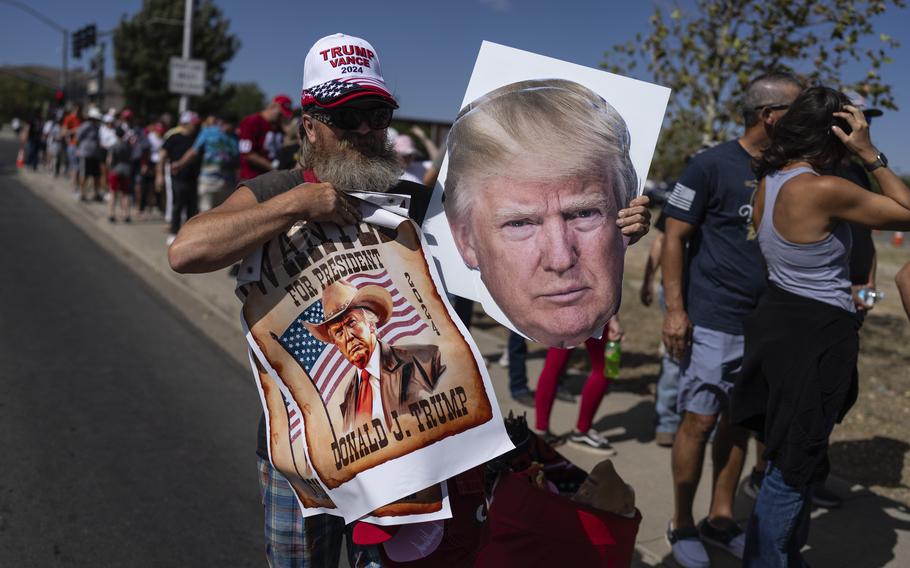 A street vendor sells posters at a rally for former President Donald Trump.