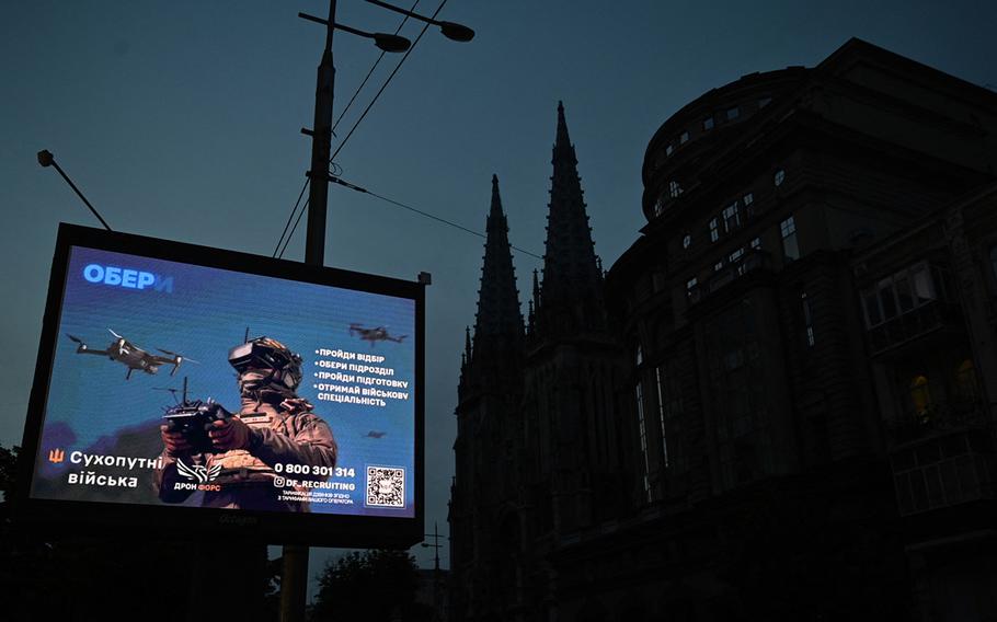 A recruiting ad for Ukraine’s military forces is seen during a partial electricity blackout in the center of Kyiv on June 22, 2024, amid Russian invasion in Ukraine.