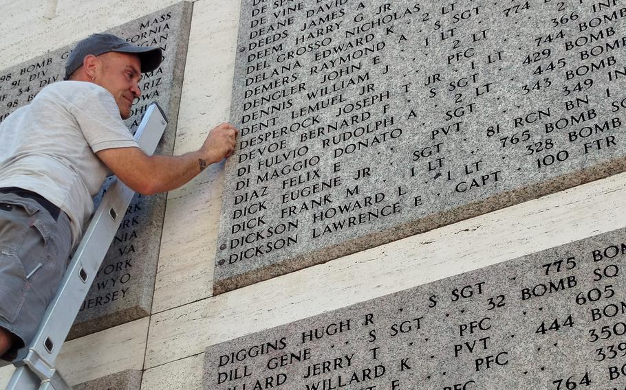 An American Battle Monuments Commission worker adds a rosette next to the name of Pfc. Lemuel Dent Jr. on July 19, 2024, at Florence American Cemetery in Italy. A rosette placed in the Wall of the Missing shows that the U.S. service member has been accounted for.