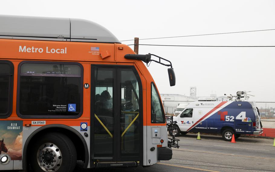 A bus passes by a news van in front of a Los Angeles MTA bus depot near the site where overnight a bus was hijacked by an armed subject with passengers on board Wednesday, Sept. 25, 2024, in Los Angeles.