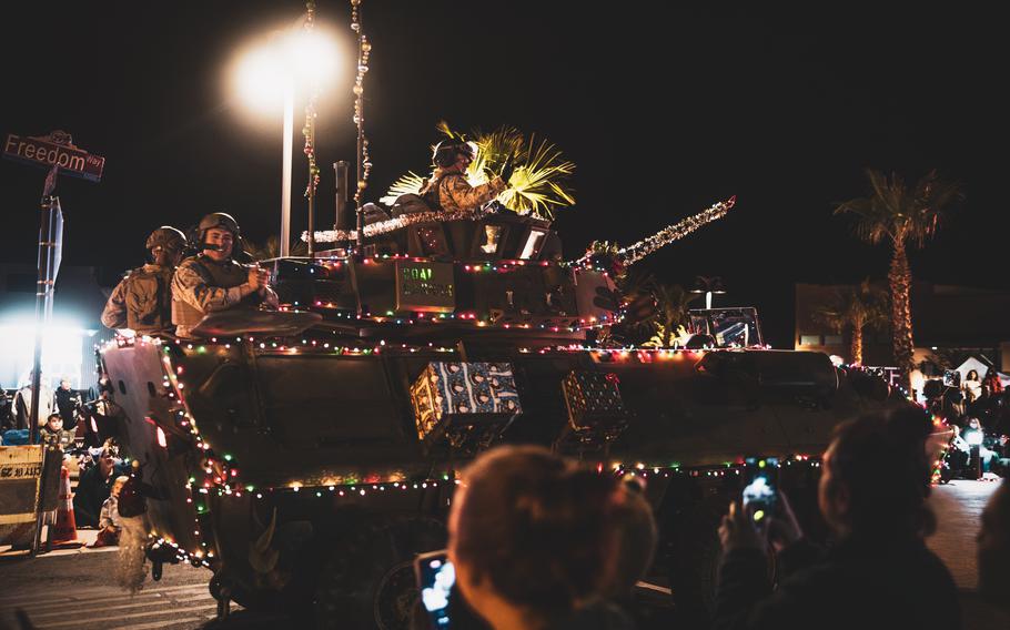 A light-armored vehicle is decorated for Christmas, covered in lights.