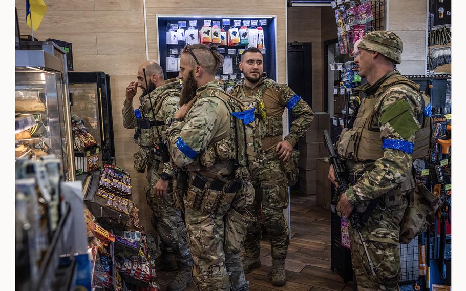 Soldiers buy coffee and hot dogs at a petrol station near Sumy. 