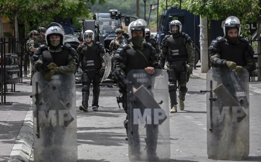 NATO soldiers and International military police secure the area near Zvecan, northern Kosovo on May 30, 2023, a day following clashes with Serb protesters demanding the removal of recently elected Albanian mayors. The situation in northern Kosovo remained tense on May 30, 2023, as ethnic Serbs continued to gather in front of a town hall in Zvecan after violent clashes with NATO-led peacekeepers left 30 soldiers injured. 