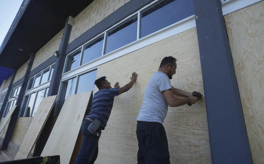 Furniture store employees board up windows for protection ahead of Hurricane Beryl's expected arrival, in Playa del Carmen, Mexico, Wednesday, July 3, 2024.