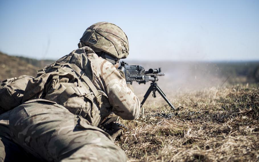 A cadet from the Royal Military Academy Sandhurst fires a machine gun.