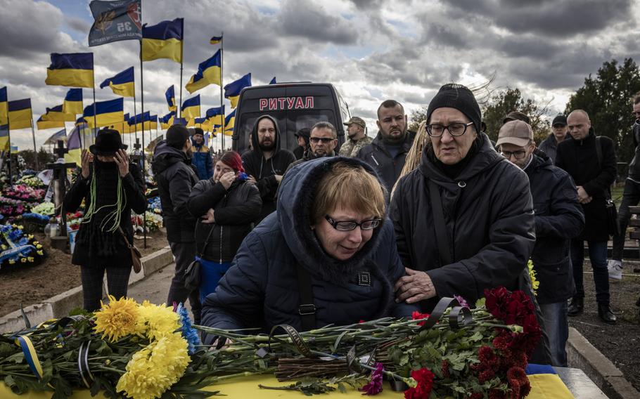 Mourners attend the funeral of a Ukrainian soldier.