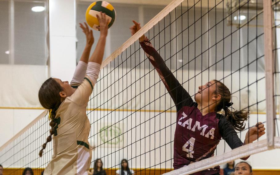 Robert D. Edgren’s Kaiya Paison and Zama’s Juliet Bitor battle for the ball during Friday’s DODEA-Japan volleyball match. The Trojans won in straight sets.