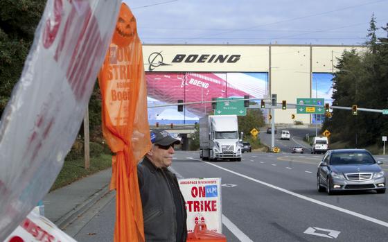 Union machinist Terry Muriekes waves a Halloween-decorated strike sign by Boeing's Everett, Wash., factory on Tuesday, Oct. 22, 2024. (AP Photo/Manuel Valdes)